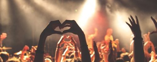 Menschenmenge bei Konzert Hände oben mit Herzform